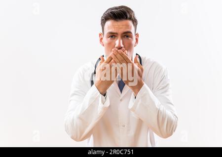 Portrait d'un médecin choqué avec les mains couvrant la bouche. Banque D'Images