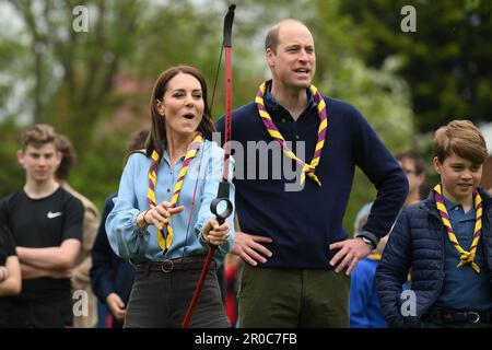 La princesse de Galles, surveillée par le prince de Galles, tente de tir à l'arc tout en se joignant à des volontaires pour aider à rénover et améliorer la cabane des Scouts Upton 3rd à Slough, dans le cadre de l'aide de grande taille, pour marquer le couronnement du roi Charles III et de la reine Camilla. Date de la photo: Lundi 8 mai 2023. Banque D'Images