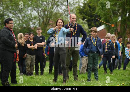 La princesse de Galles, surveillée par le prince de Galles, tente de tir à l'arc tout en se joignant à des volontaires pour aider à rénover et améliorer la cabane des Scouts Upton 3rd à Slough, dans le cadre de l'aide de grande taille, pour marquer le couronnement du roi Charles III et de la reine Camilla. Date de la photo: Lundi 8 mai 2023. Banque D'Images