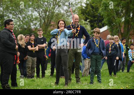 La princesse de Galles, surveillée par le prince de Galles, tente de tir à l'arc tout en se joignant à des volontaires pour aider à rénover et améliorer la cabane des Scouts Upton 3rd à Slough, dans le cadre de l'aide de grande taille, pour marquer le couronnement du roi Charles III et de la reine Camilla. Date de la photo: Lundi 8 mai 2023. Banque D'Images