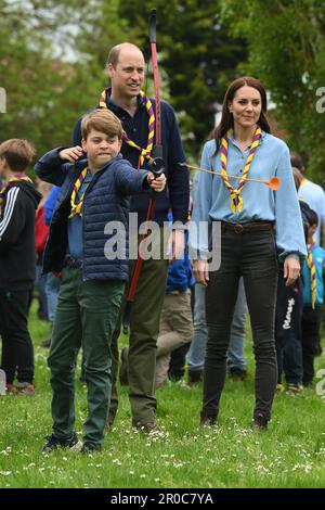 Le Prince George, observé par le Prince et la Princesse de Galles, tente de tir à l'arc tout en se joignant à des bénévoles pour aider à rénover et à améliorer la cabane des Scouts Upton 3rd à Slough, dans le cadre de la grande aide, pour marquer le couronnement du roi Charles III et de la reine Camilla. Date de la photo: Lundi 8 mai 2023. Banque D'Images