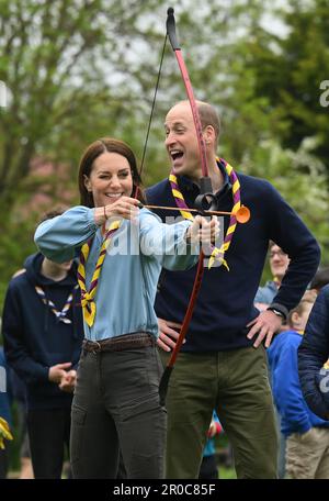 La princesse de Galles, surveillée par le prince de Galles, tente de tir à l'arc tout en se joignant à des volontaires pour aider à rénover et améliorer la cabane des Scouts Upton 3rd à Slough, dans le cadre de l'aide de grande taille, pour marquer le couronnement du roi Charles III et de la reine Camilla. Date de la photo: Lundi 8 mai 2023. Banque D'Images