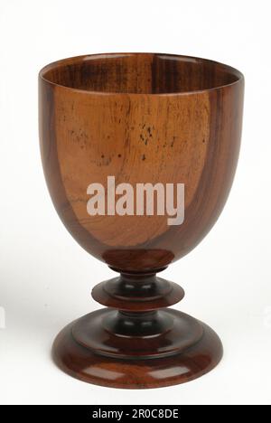 Coupe - gobelet, 1700-1800. Fabriqué en Angleterre. Collection Pinto - acheté de Edward H Pinto, 1965.. Ce gobelet en bois de laburnum est l'un des deux, probablement datant du XVIIIe siècle. On peut dire qu'il a été fait sur un tour de poteau parce que le point où le gobelet a été tenu en place sur le tour laisse une marque caractéristique sur la base. Il est très difficile de dater ces gobelets en bois simple avec précision, car les styles et les modèles ont changé très lentement au fil des ans. Le bois de Laburnum était un choix intéressant pour ce gobelet car ses tons chauds et son coeur sombre contrasté et aubier jaune l'aident à ajouter un Banque D'Images