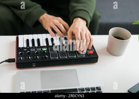 Vue de dessus du producteur ou de l'arrangeur de musique à l'aide d'un ordinateur portable, d'un clavier midi et d'autres équipements audio pour créer de la musique dans un studio à domicile. Battre et Banque D'Images