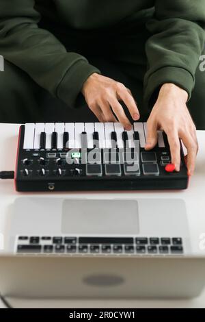 Vue de dessus du producteur ou de l'arrangeur de musique à l'aide d'un ordinateur portable, d'un clavier midi et d'autres équipements audio pour créer de la musique dans un studio à domicile. Battre et Banque D'Images