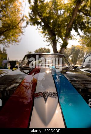 Image détaillée d'une voiture classique dans une palette de couleurs vives avec des bandes de drapeaux bleu, rouge et blanc Banque D'Images