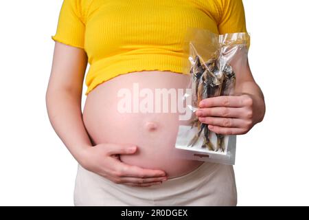 Poisson séché dans les mains d'une femme enceinte, isolé sur fond blanc Banque D'Images