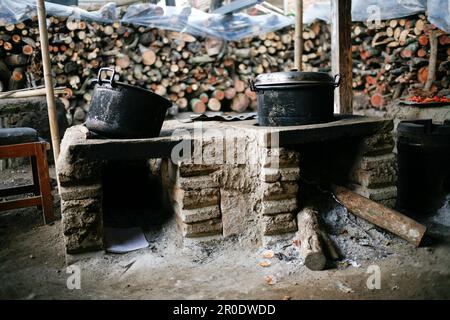 Cuisine rurale. Poêles traditionnels utilisés par les résidents en Indonésie rurale, fait d'argile, alimenté avec du bois, cuisant la nourriture sur le sol cuisinière avec feuilles sèches et Banque D'Images