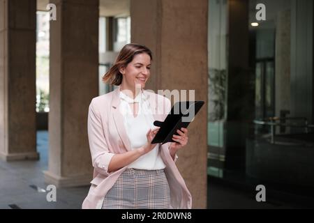 Femme d'affaires qui se repose en prenant soin de son travail avec la tablette. Concept : entreprise, femme d'affaires, entrepreneuriat Banque D'Images