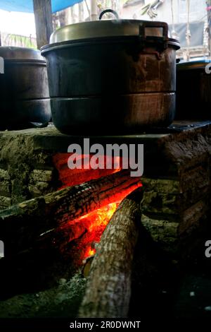 Cuisine rurale. Poêles traditionnels utilisés par les résidents en Indonésie rurale, fait d'argile, alimenté avec du bois, cuisant la nourriture sur le sol cuisinière avec feuilles sèches et Banque D'Images