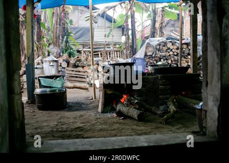 Cuisine rurale. Poêles traditionnels utilisés par les résidents en Indonésie rurale, fait d'argile, alimenté avec du bois, cuisant la nourriture sur le sol cuisinière avec feuilles sèches et Banque D'Images