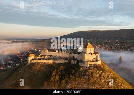 Vue aérienne sur le château de Sumeg avec un lever de soleil brumeux à l'arrière-plan. Banque D'Images