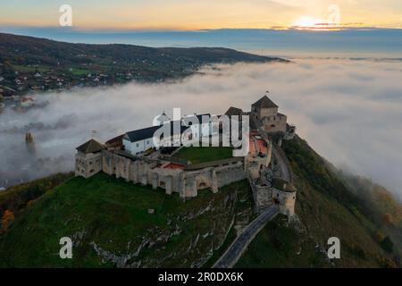 Vue aérienne sur le château de Sumeg avec un lever de soleil brumeux à l'arrière-plan. Banque D'Images