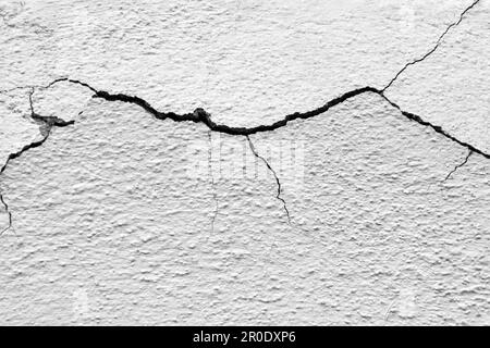 Grande fissure horizontale d'enroulement sur l'ancien mur de plâtrage blanc. Copier l'espace. Mise au point sélective. Banque D'Images