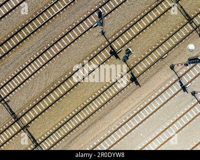 Sept voies de chemin de fer parallèles sur le Gavel avec des traverses de chemin de fer en béton montré en diagonale. Signaler les ombres de la lumière des pôles verticaux. Vue aérienne avant Banque D'Images