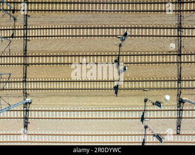 Six voies de chemin de fer parallèles sur la Gavel avec des traverses de chemin de fer en béton, traction électrique et feux de signalisation. Ombres des pôles verticaux. Vue aérienne avant Banque D'Images