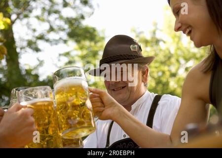 Un homme bavarois plus âgé et une jeune femme qui se toasque, Munich, Bavière Banque D'Images