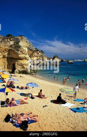 Les gens sur la plage au soleil, Porio do Camilo, Lagos, Algarve, Portugal, Europe Banque D'Images