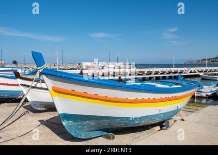 Des bateaux de pêche traditionnels colorés amarrés dans le petit port du sud de l'Italie lors d'une journée d'été ensoleillée avec la mer bleue et le ciel. Sicile, Mondello, Palerme Banque D'Images