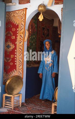 Ibrahim, Berber debout à l'entrée d'une maison portant des vêtements traditionnels, Berber Appartement avec la main de Fatima, Tafraoute, anti-Atlas, Marocco Banque D'Images