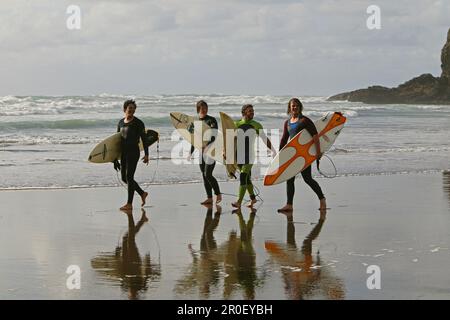 Surfeurs, Piha surf Beach, Piha Beach, côte ouest près d'Auckland, surfeur avec surf, Nouvelle-Zélande Banque D'Images