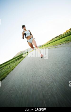 Young woman jogging on country road Banque D'Images