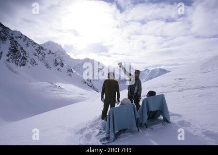 Deux jeunes gens de vous détendre sur des chaises longues, deux autres debout à côté, Kuehtai, Tyrol, Autriche Banque D'Images