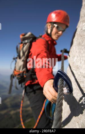 Jeune femme grimpeur sur la route fixe de la corde de Donnerkogel, montagne de Dachstein, Autriche Banque D'Images