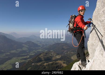 Jeune femme grimpeur sur la route fixe de la corde de Donnerkogel, montagne de Dachstein, Autriche Banque D'Images