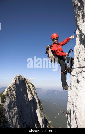 Jeune femme grimpeur sur la route fixe de la corde de Donnerkogel, montagne de Dachstein, Autriche Banque D'Images