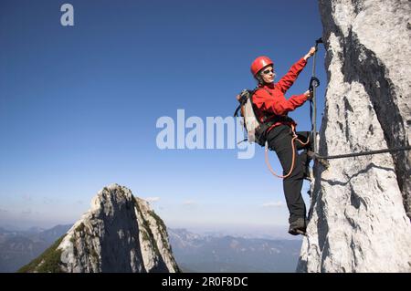 Jeune femme grimpeur sur la route fixe de la corde de Donnerkogel, montagne de Dachstein, Autriche Banque D'Images