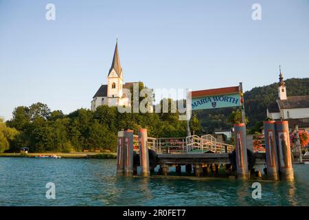 Vue sur Woerthersee le plus grand lac de Carinthie jusqu'à l'église paroissiale Maria Woerth, Carinthie, Autriche Banque D'Images