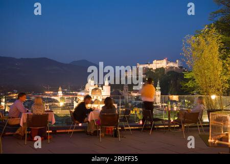 Personnes assises sur la terrasse du restaurant Mönchsberg 32 dans la soirée, vue sur la vieille ville avec la forteresse Hohensalzburg, Salzbourg, Salzbourg, Autriche, Banque D'Images