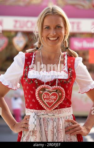 Mid adult woman wearing dirndl dress avec un coeur de chocolat Banque D'Images