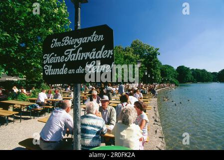 Personnes assises à Beergarden Seehaus, jardin anglais, Munich, Bavière, Allemagne Banque D'Images