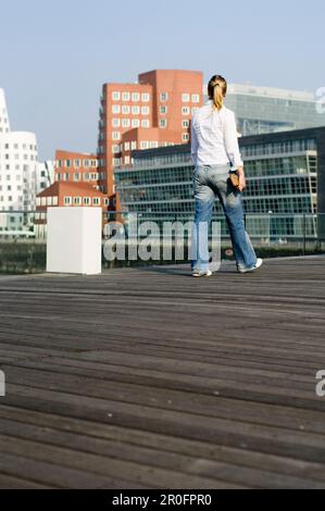 Femme marchant dans Media Harbour, Dusseldorf, Rhénanie-du-Nord-Westphalie, Allemagne Banque D'Images