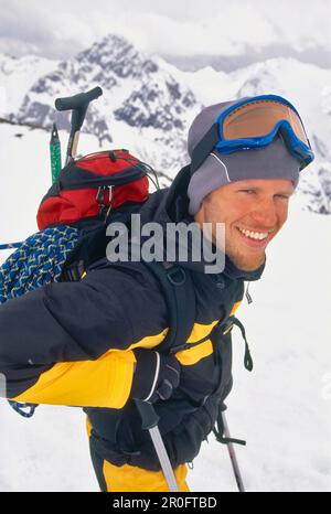 Jeune homme en train de carrier la corde d'escalade et la hache de glace lors d'une visite de ski, escalade de glace, sports d'hiver, sports, Alpes de Stubai, Tyrol, Autriche Banque D'Images