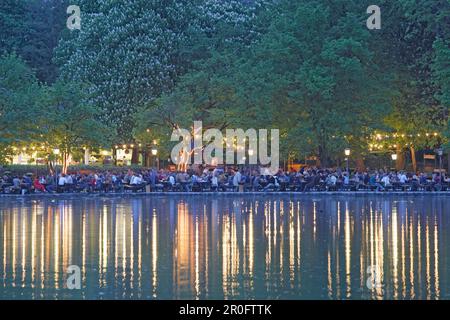 Les gens s'amusent au café en plein air Seehaus at Kleinhesseloher See in the Evening, English Garden, Munich, Bavière, Allemagne Banque D'Images