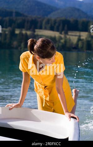 Jeune femme barbotant avec les pieds dans le lac Walchensee, Bavière, Allemagne Banque D'Images