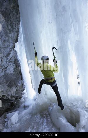 Grimpeur de glace sur une cascade gelée, Immenstadt, Bavière, Allemagne Banque D'Images