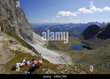 Deux randonneurs se trouvant sur l'herbe, Alpes de Stubai, Stubai, Tyrol du Sud, Italie Banque D'Images