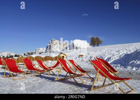 Transats rouges dans la neige, Seiser Alm, Dolomites, Trentin-Haut-Adige/Südtirol, Italie Banque D'Images