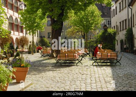 Serveuse posant la table à Beergarden, Regensburg, Haut-Palatinat, Bavière, Allemagne Banque D'Images