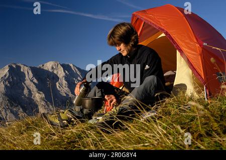 Jeune femme assise en face d'une tente dans les montagnes, Tyrol, Autriche, Europe Banque D'Images