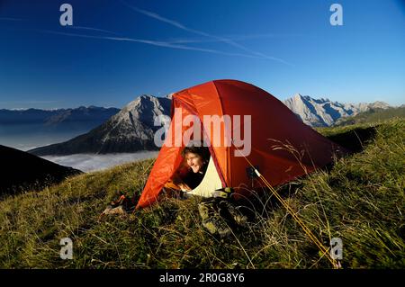 Jeune femme à la recherche d'une tente dans les montagnes, Tyrol, Autriche, Europe Banque D'Images