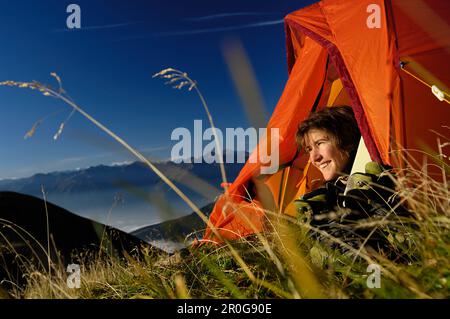 Jeune femme à la recherche d'une tente dans les montagnes, Tyrol, Autriche, Europe Banque D'Images