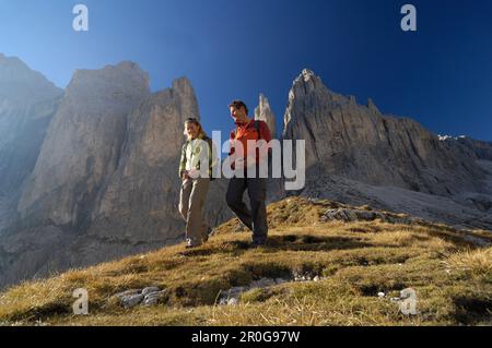 Couple hiking dans les montagnes, Val di Fassa, Rosengarten, Dolomites, Trento, Tyrol du Sud, Italie Banque D'Images