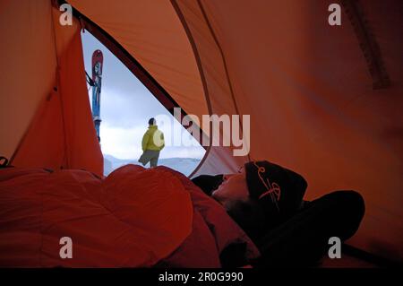 Femme à l'intérieur d'une tente à l'extérieur, Camping en hiver à Hochgrat, Allgäu Alpes, Bavière, Allemagne, Europe Banque D'Images