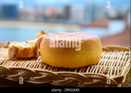 Fromage de vache fumé espagnol de Pria, Asturies, servi en plein air avec vue sur la plage de San Lorenzo et la promenade de Gijon Banque D'Images