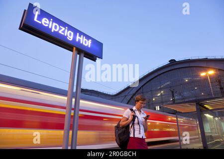 Femme avec téléphone mobile sur plateforme, Leipzig, Saxe, Allemagne Banque D'Images